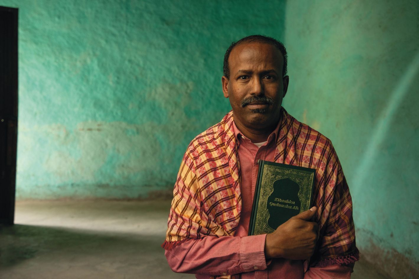 Mees somaalia rätikus hoiab Piiblit.